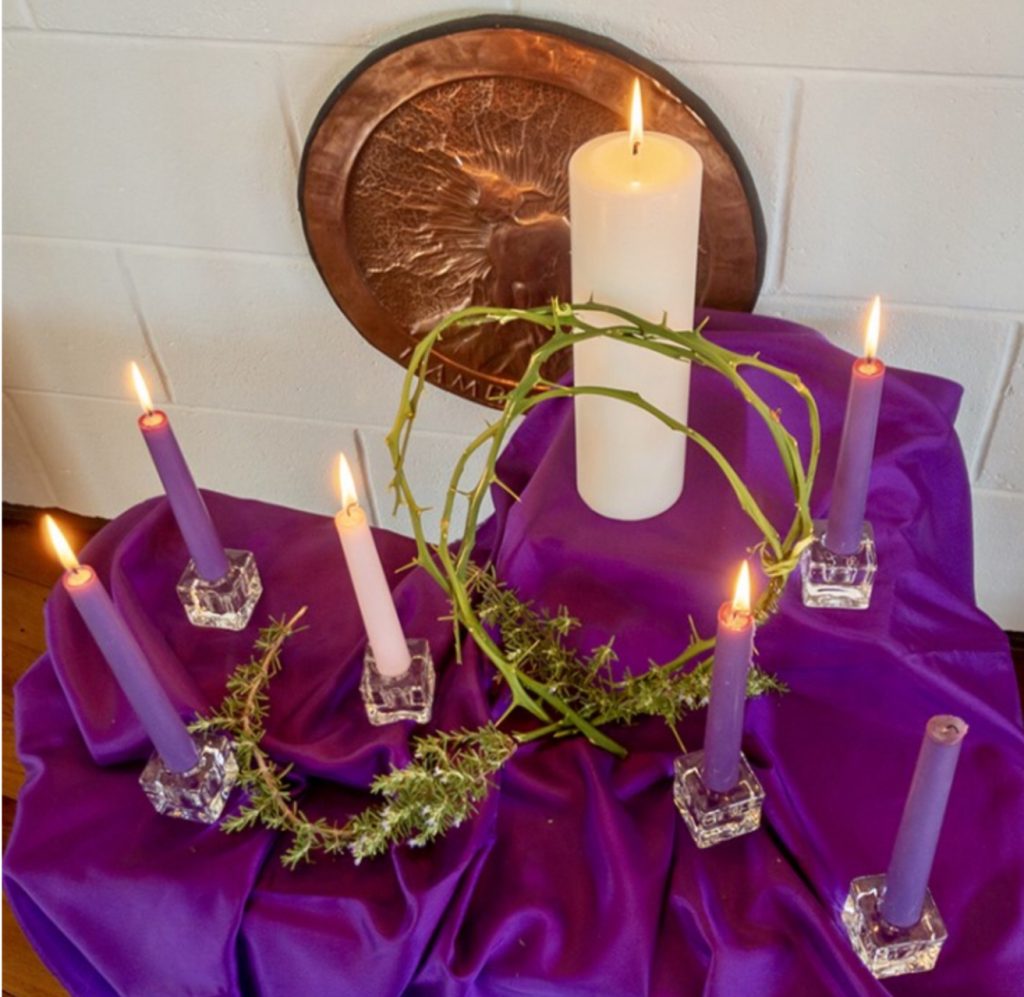 Table in front of altar with purple cloth, candles and crown of thorns