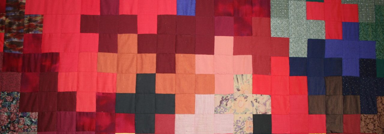 Close up of quilt at Holy Cross with crosses in reds, blues and greens
